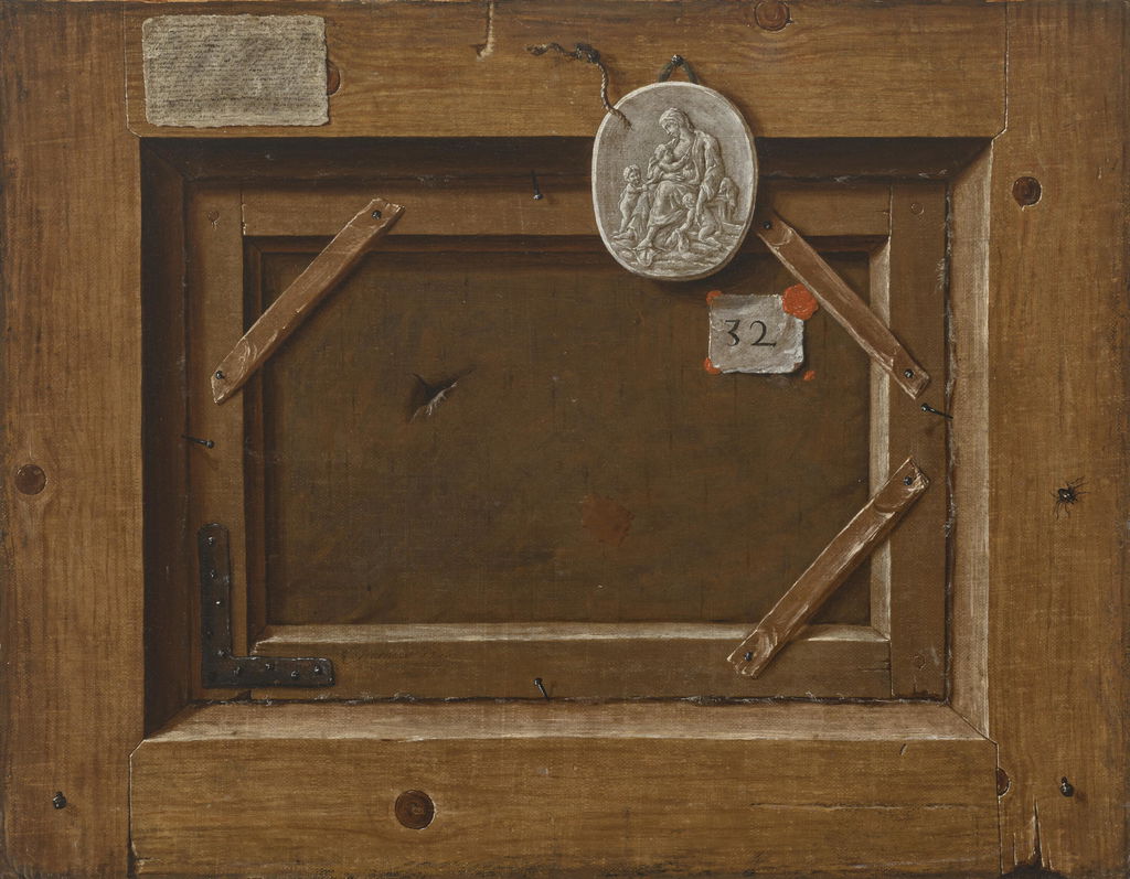 A trompe l'oeil of the back of a painting with a plaster medallion of Charity, an extensively inscribed label, an inventory number with red wax, and a spider. Image courtesy of Sotheby's