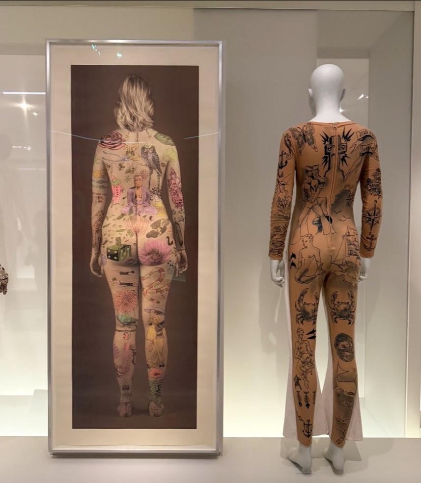 Installation view of Jane Hammond's Tabula Rosa next to Jean Paul Gaultier's tattoo jumpsuit.